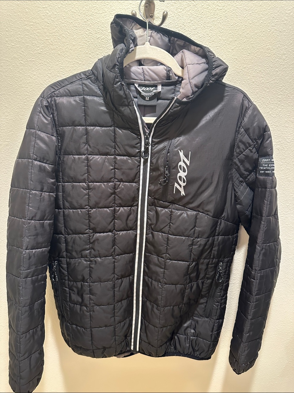 Zoot Sports Women’s Black Puffer with attached hood.